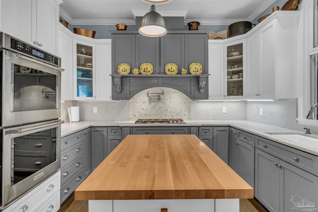 kitchen with butcher block countertops, gray cabinetry, sink, and appliances with stainless steel finishes