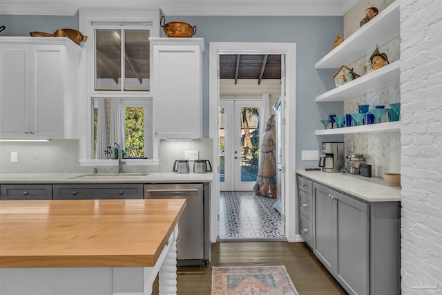 kitchen featuring wood counters, stainless steel dishwasher, sink, gray cabinets, and dark hardwood / wood-style floors