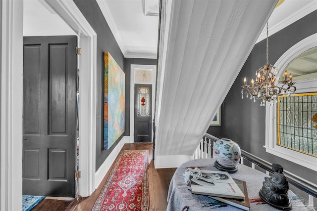 entryway featuring dark hardwood / wood-style floors, crown molding, and a chandelier