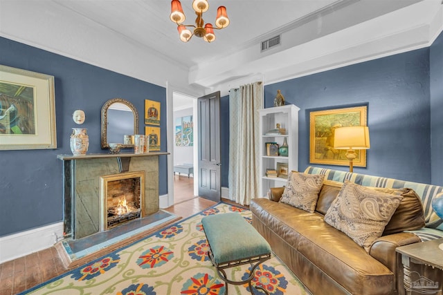 living room with an inviting chandelier, light hardwood / wood-style floors, and ornamental molding