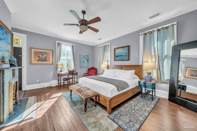 bedroom with ceiling fan, hardwood / wood-style floors, and crown molding