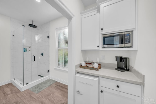 bathroom featuring hardwood / wood-style flooring and a shower with shower door