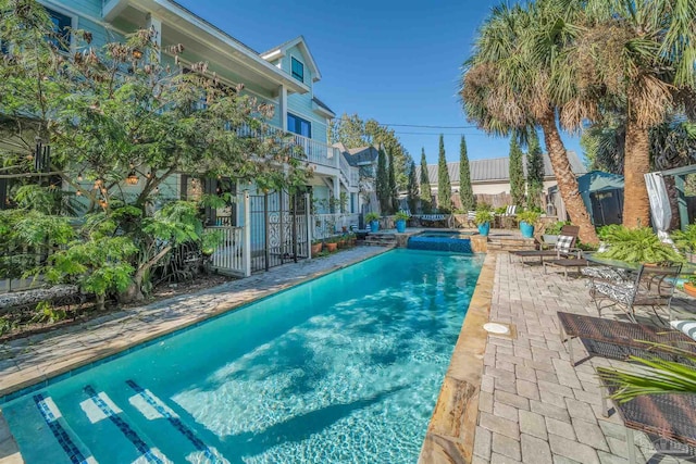 view of swimming pool featuring an in ground hot tub and a patio