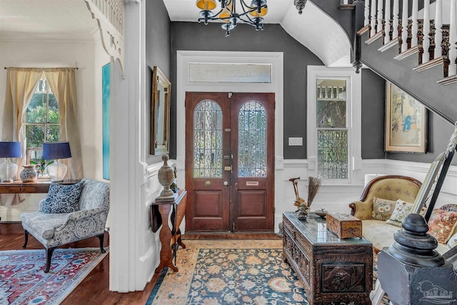 entryway featuring lofted ceiling, french doors, a notable chandelier, and hardwood / wood-style flooring