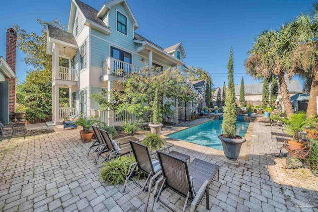 view of patio / terrace with a balcony and a fenced in pool