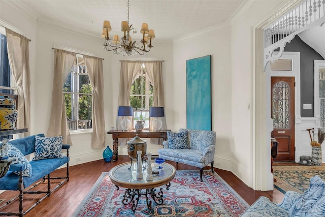 living area featuring dark hardwood / wood-style floors, lofted ceiling, ornamental molding, and an inviting chandelier