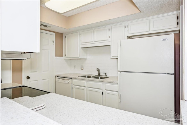 kitchen with a sink, white appliances, light countertops, backsplash, and visible vents