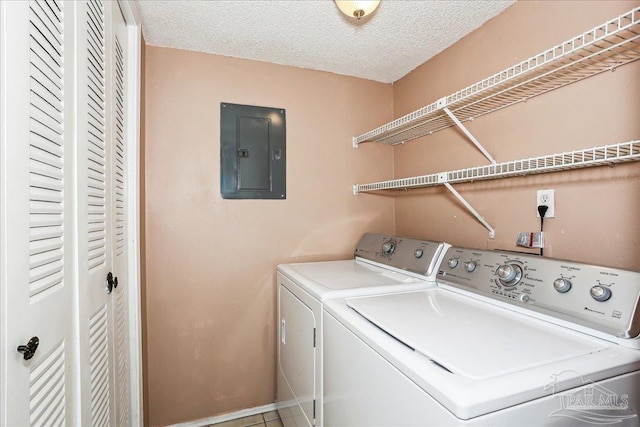 clothes washing area featuring separate washer and dryer, laundry area, a textured ceiling, and electric panel