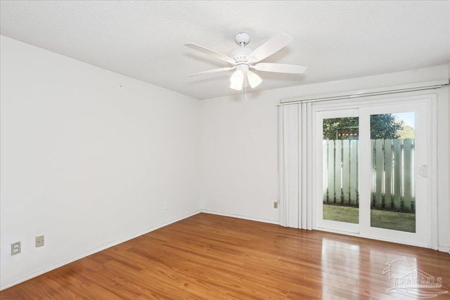 unfurnished room with wood finished floors, a textured ceiling, baseboards, and ceiling fan