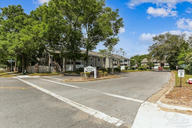 view of street with traffic signs, a residential view, curbs, and stairs