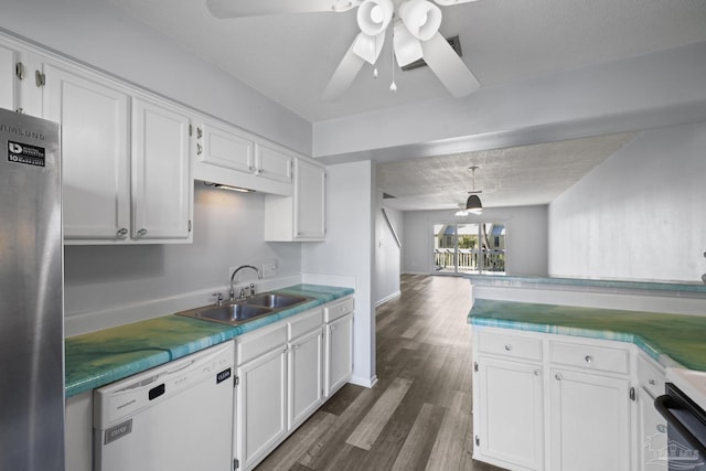 kitchen with white dishwasher, white cabinetry, and sink