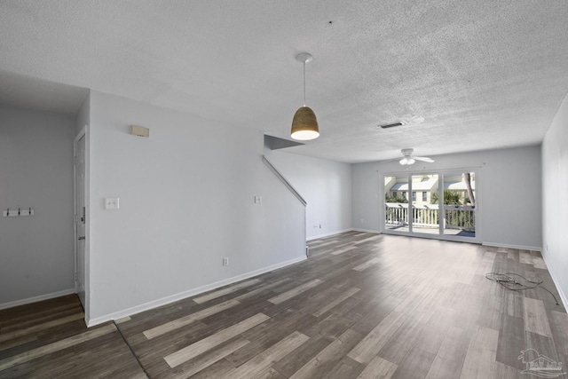 unfurnished living room with dark hardwood / wood-style flooring, a textured ceiling, and ceiling fan