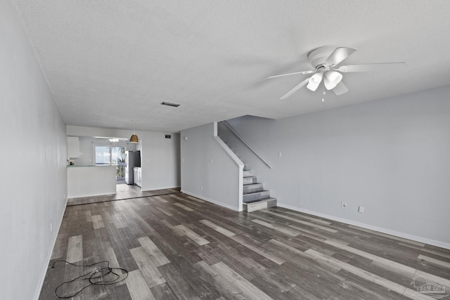 unfurnished living room with ceiling fan, dark wood-type flooring, and a textured ceiling