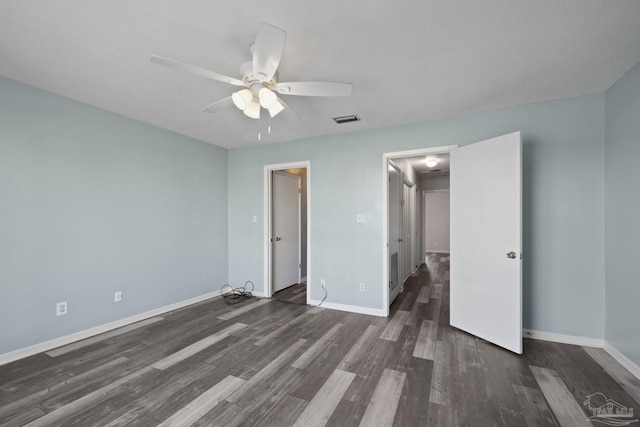 unfurnished bedroom featuring ceiling fan and dark wood-type flooring