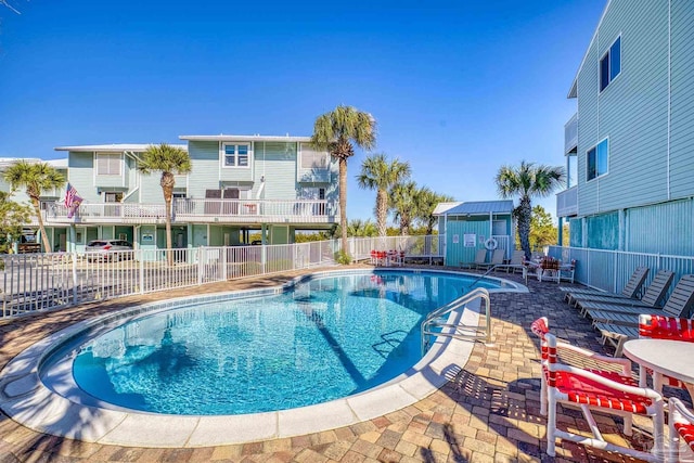 view of swimming pool featuring a patio area and a storage shed