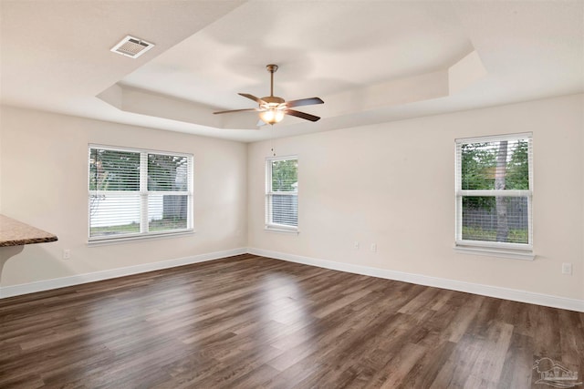 spare room with ceiling fan, dark hardwood / wood-style flooring, and a wealth of natural light