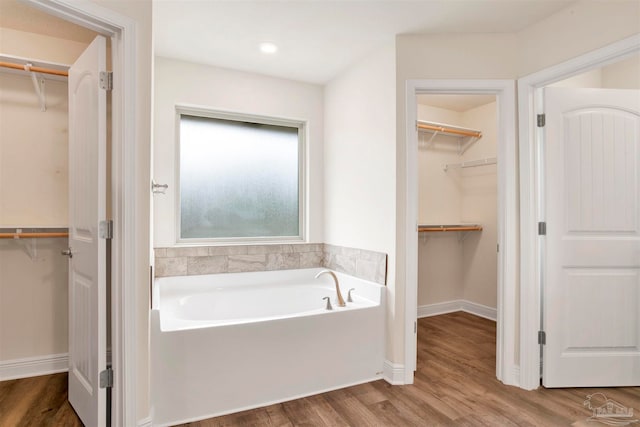 bathroom featuring a tub to relax in and hardwood / wood-style floors