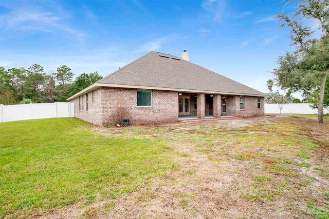 rear view of property with a lawn and a patio area