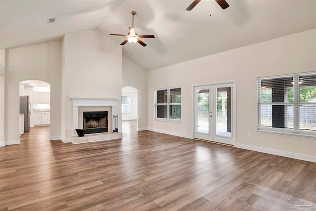 unfurnished living room featuring wood-type flooring, high vaulted ceiling, and ceiling fan