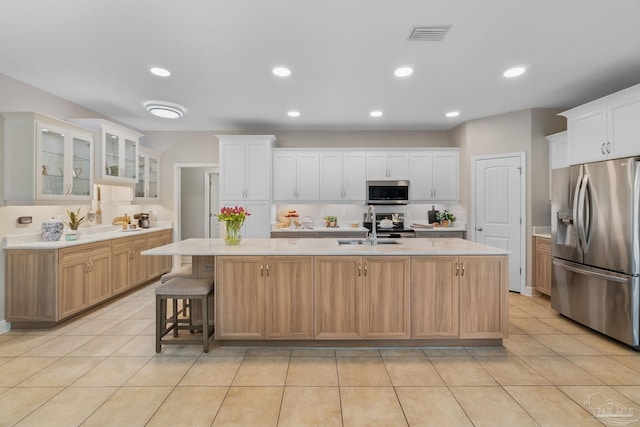 1777 Waterford Sound Blvd, Gulf Breeze, FL 32563 - kitchen featuring appliances with stainless steel finishes, light countertops, a center island with sink, light tile patterned flooring, and recessed lighting
