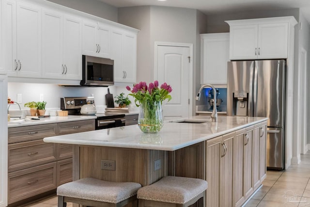 1777 Waterford Sound Blvd, Gulf Breeze, FL 32563 - kitchen with appliances with stainless steel finishes, a sink, white cabinetry, an island with sink, and light tile patterned floors