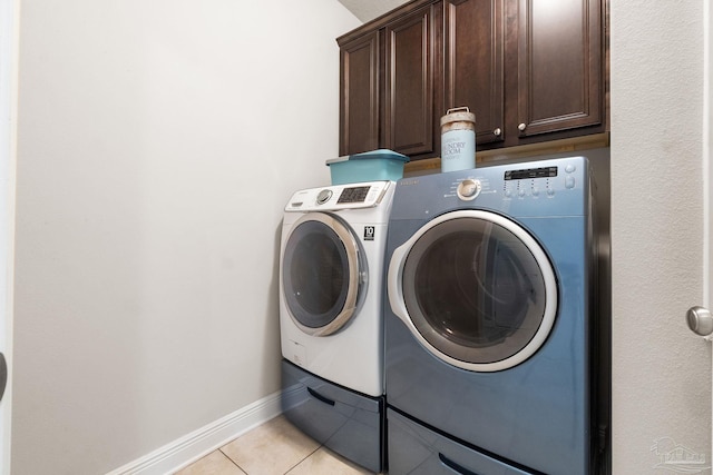 1777 Waterford Sound Blvd, Gulf Breeze, FL 32563 - laundry area with cabinet space, washing machine and clothes dryer, light tile patterned flooring, and baseboards