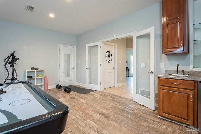 recreation room with light hardwood / wood-style floors, sink, and french doors