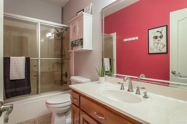 full bathroom featuring tile patterned floors, vanity, bath / shower combo with glass door, and toilet