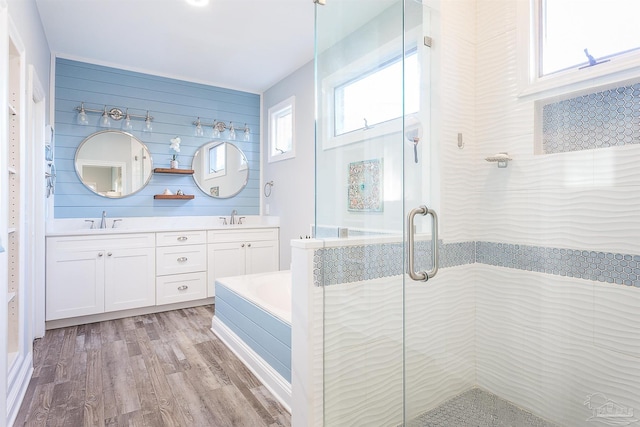 bathroom with hardwood / wood-style floors, vanity, and shower with separate bathtub