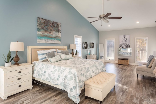 bedroom with ceiling fan, dark hardwood / wood-style flooring, high vaulted ceiling, and multiple windows