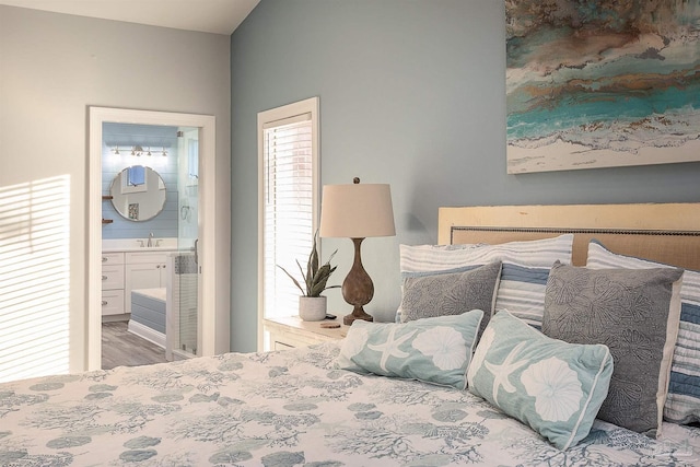 bedroom featuring ensuite bath, sink, and hardwood / wood-style flooring