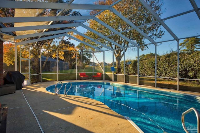 view of swimming pool with a lanai, a grill, and a patio area