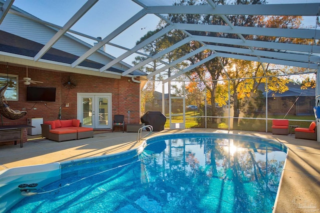 view of pool featuring glass enclosure, french doors, ceiling fan, a grill, and a patio area