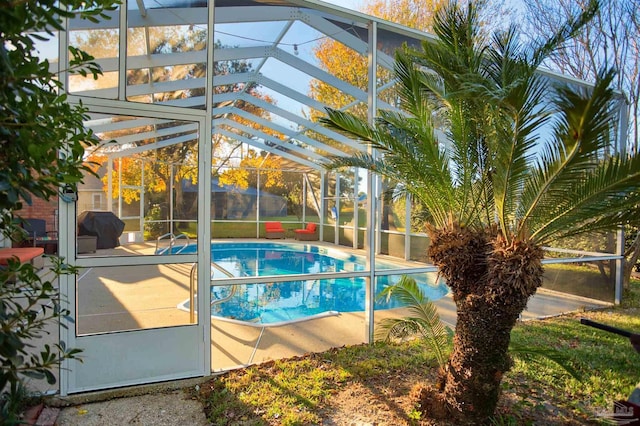 view of pool with glass enclosure