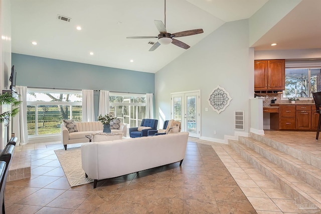 living room with ceiling fan, built in desk, high vaulted ceiling, and french doors