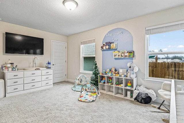 playroom with a textured ceiling and light carpet