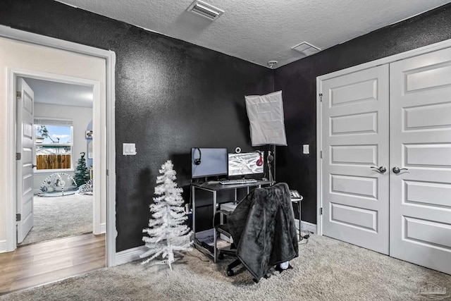 office space featuring carpet and a textured ceiling