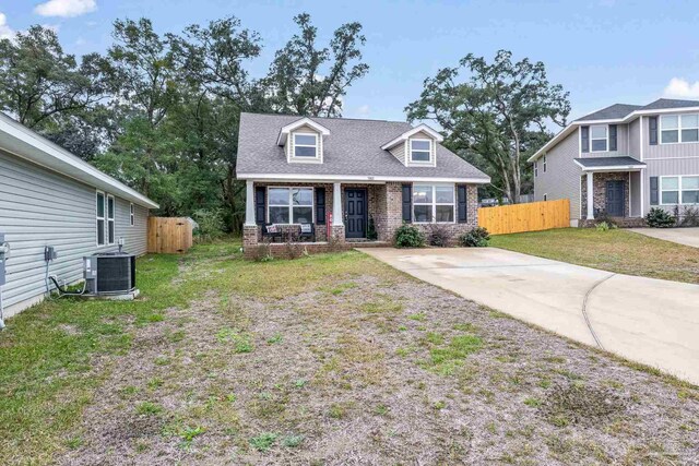 view of front of house with central AC and a front yard