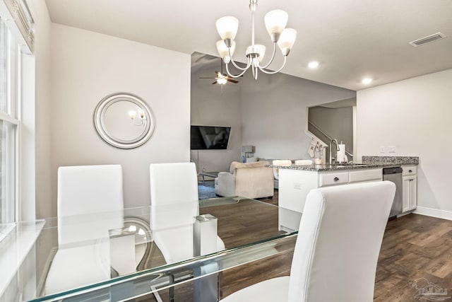 dining area featuring dark hardwood / wood-style flooring, ceiling fan with notable chandelier, and sink