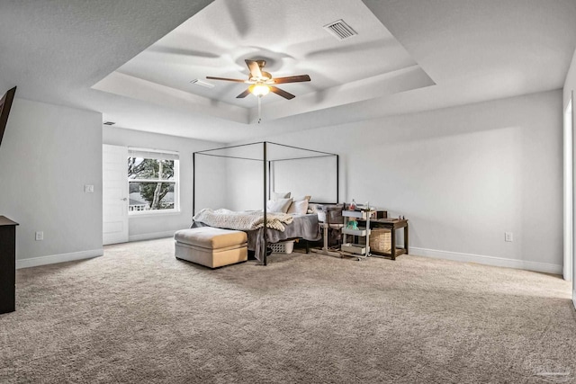 bedroom with carpet, ceiling fan, and a tray ceiling