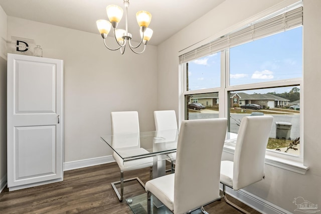 dining area with dark hardwood / wood-style flooring and a chandelier