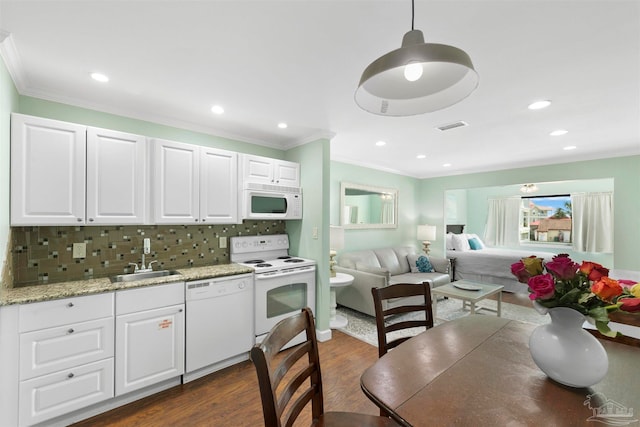 kitchen with white appliances, white cabinets, dark hardwood / wood-style flooring, decorative backsplash, and sink