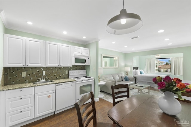 kitchen featuring sink, white appliances, white cabinetry, hanging light fixtures, and dark hardwood / wood-style floors