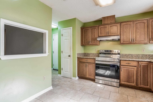 kitchen featuring light tile patterned flooring, a textured ceiling, light stone counters, and stainless steel electric range