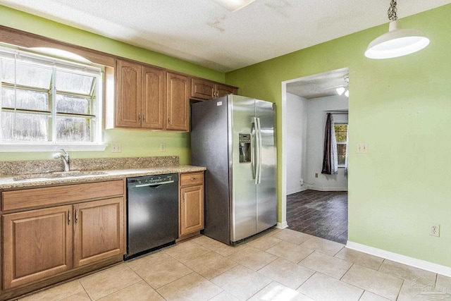 kitchen featuring a textured ceiling, sink, decorative light fixtures, dishwasher, and stainless steel fridge with ice dispenser