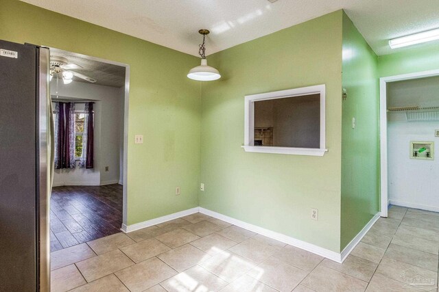 empty room with a textured ceiling, light hardwood / wood-style flooring, and ceiling fan