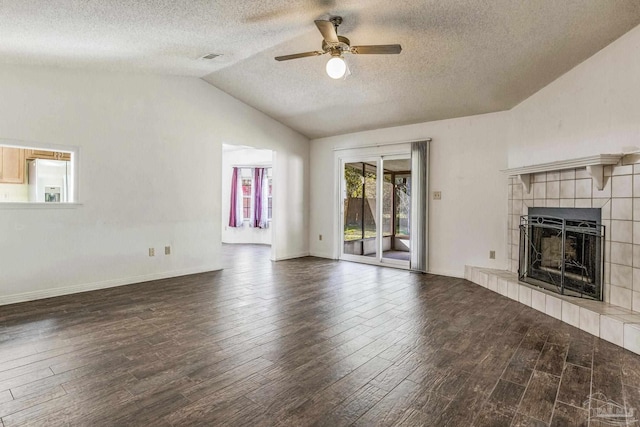 unfurnished living room featuring vaulted ceiling, ceiling fan, a fireplace, a textured ceiling, and dark hardwood / wood-style flooring