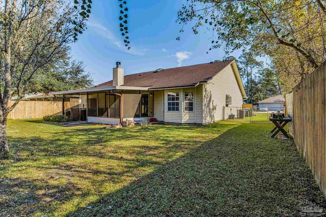 back of house with a yard and a sunroom