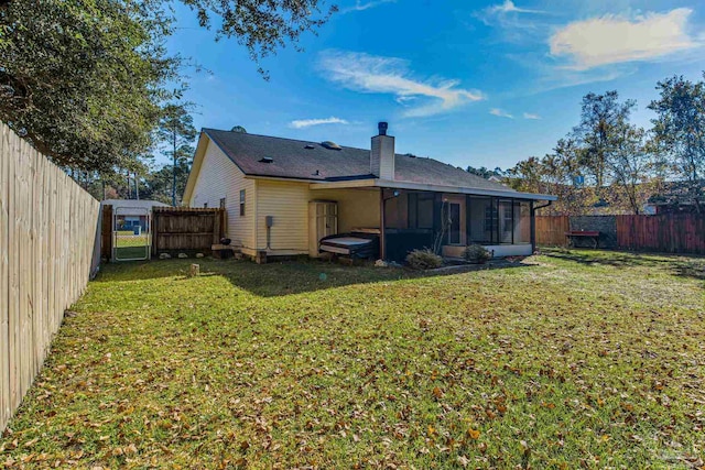 back of property featuring a sunroom and a lawn