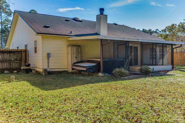 back of house featuring a yard and a sunroom